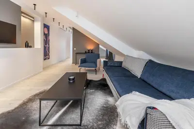 a living room with a blue couch and a table at Artsy Exclusive Old Town Residence Gallery Walk in Vilnius