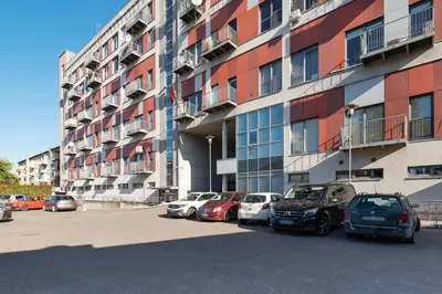 a parking lot with cars parked in front of a building at Panoramic city centre apartment by Polo Apartments in Kaunas