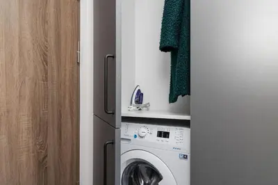 a kitchen with a washing machine and a refrigerator at River To The City - Self check in in Vilnius