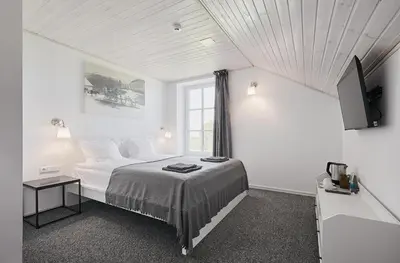 a white bedroom with a bed and a window at Bebryno slėnis in Staškūniškis